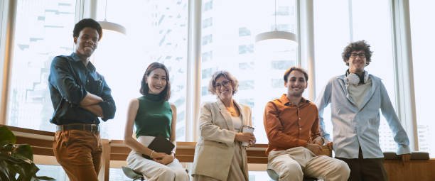 Group portrait of multi-ethnic businesspeople smiling in a modern office.
