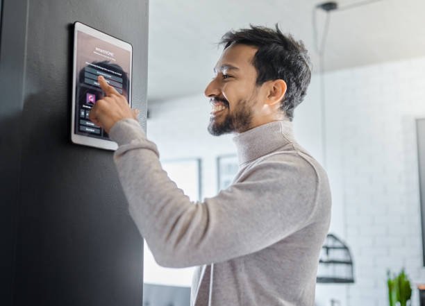 Man using digital dashboard screen for smart home lighting and security control.