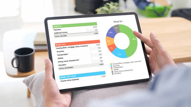Hand interacting with a digital tablet displaying personal financial account dashboard, representing telefinance and modern lifestyle.