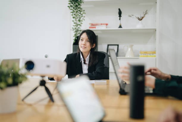 A young professional woman in a business suit at a meeting, representing Personal Finance Tips for Millennials in a work or planning context.