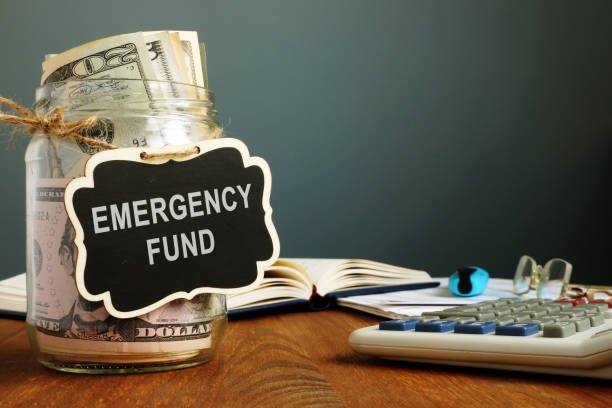 Emergency fund savings written on the jar with money. fund