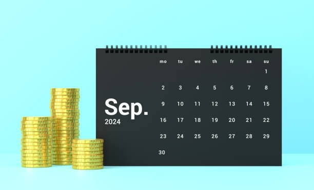 A black September calendar next to stacks of gold coins, symbolizing the September Money Reset and getting your budget back on track.