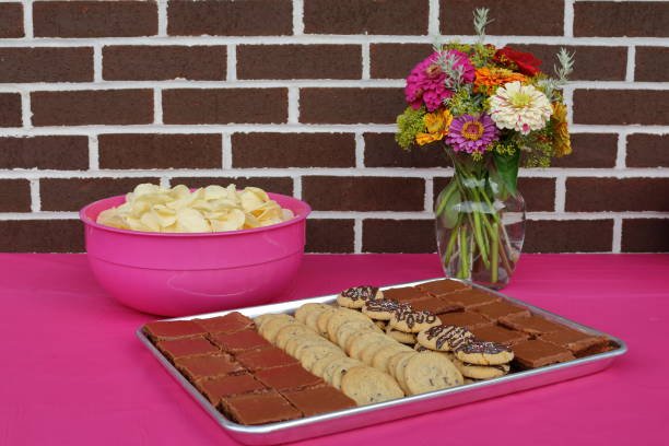 a tray of cookies and brownies waits on a picnic table.
