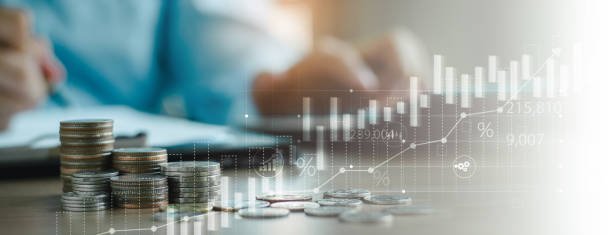 A hand places a coin into a glass representing diverse investments like gold, a shield for safe assets, and a house for real estate, against a backdrop of a global map with downward and upward trend arrows on a computer screen, symbolizing Investing During a Global Slowdown: Where to Put Your Money.