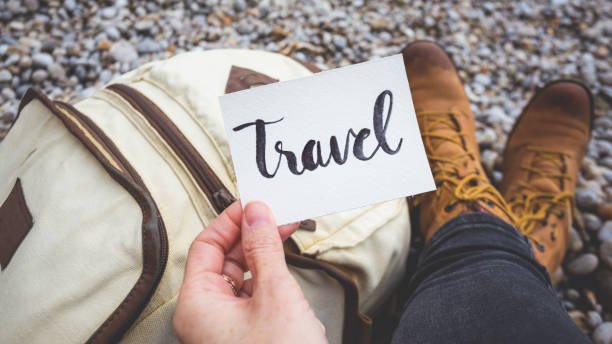 A traveler holding a white paper written travel in a cozy nature
